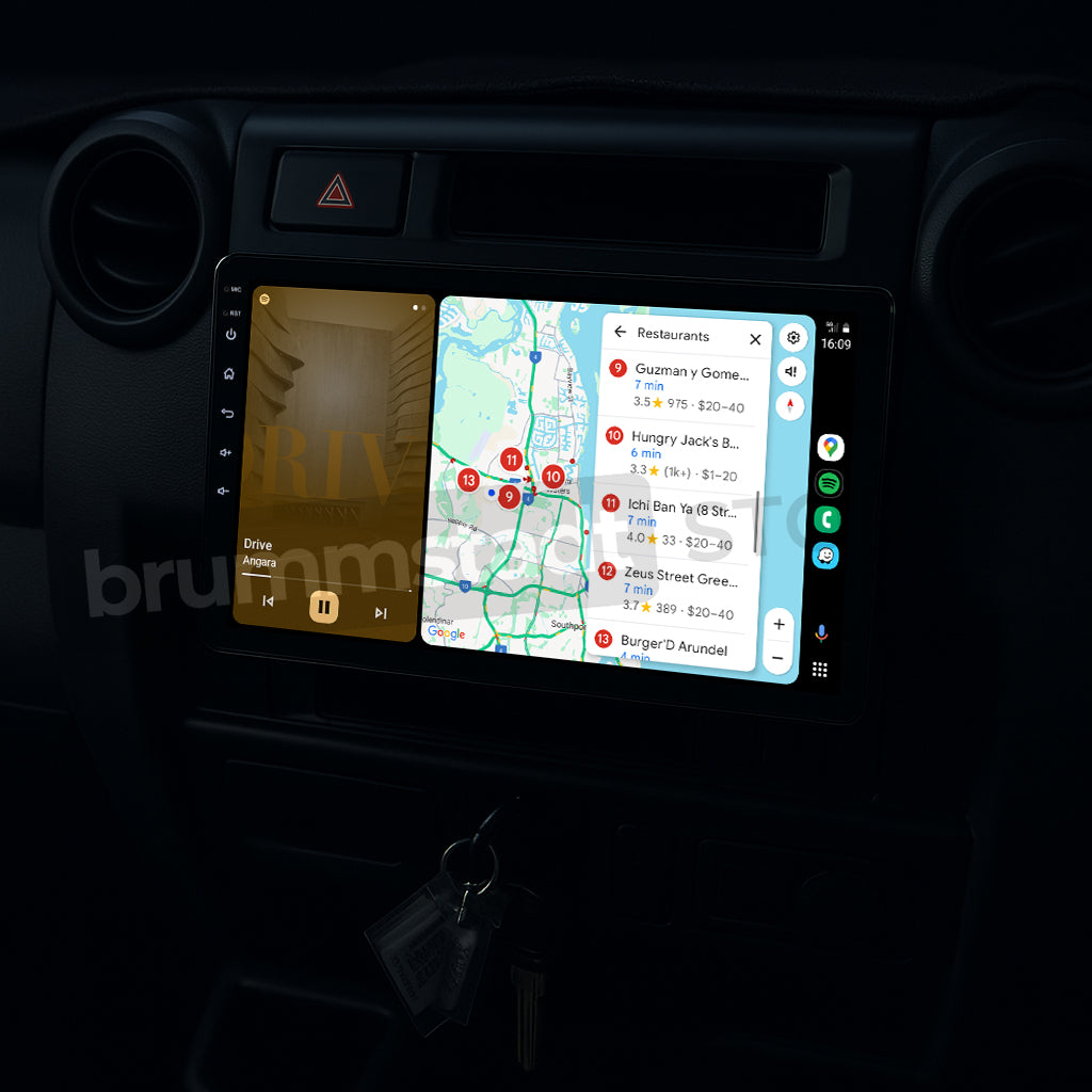 Brummstadt, Toyota Land Cruiser 70 Series 1984-2025, Toyota Land Cruiser 70 Series, Android Auto interface, visible apps include Maps and Spotify, navigation map with restaurant locations, music player interface, home button, microphone icon, time display, signal strength, battery status, sleek modern infotainment, user-friendly layout, premium upgrade kit, Brummstadt.