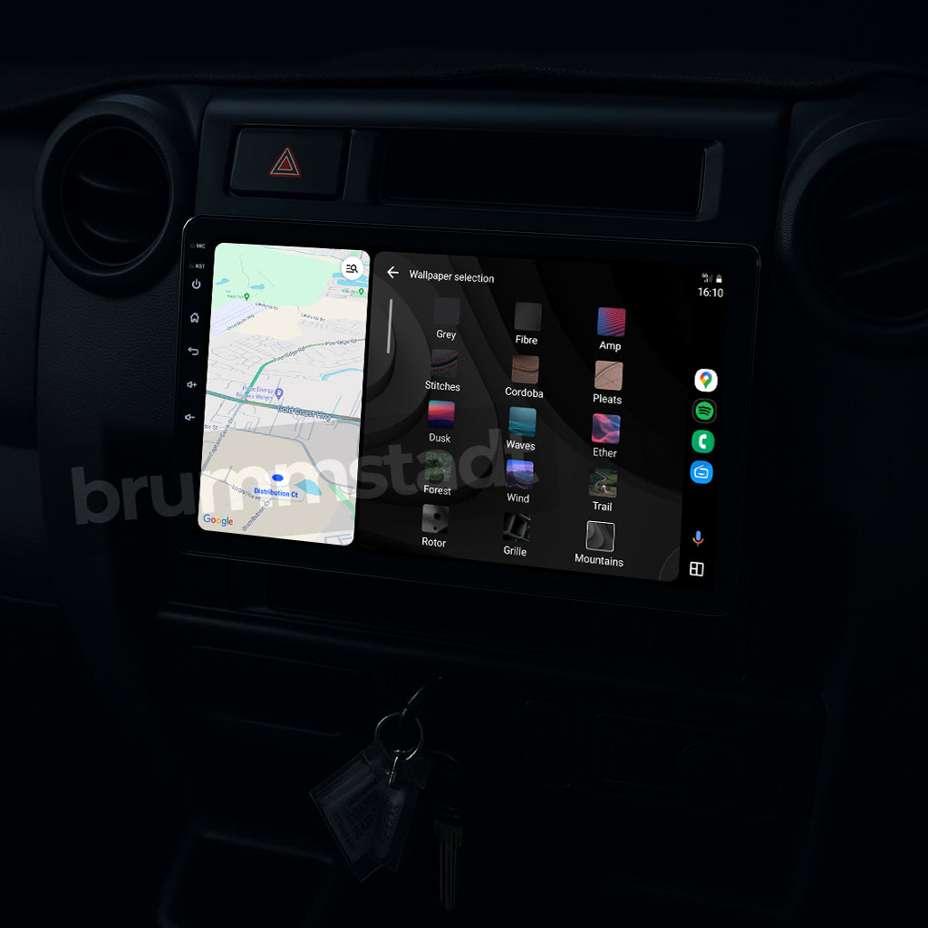 Brummstadt, Toyota Land Cruiser 70 Series 1984-2025, showcasing Android Auto interface with Google Maps navigation on the left and wallpaper selection menu on the right. The head unit displays a grid of app icons including Maps, Cordoba, Ether, and Trail. The screen features a sleek, modern design with easy access to essential apps. Toyota Land Cruiser's dashboard integrates seamlessly with Android Auto, enhancing user experience.
