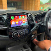 Toyota Hilux 2007-14 dash with glossy 9-inch Apple CarPlay & Android Auto head unit, vivid icons, steering-wheel control, OEM-style fascia, phone mirroring, Bluetooth, reversing-camera ready. Brummstadt.com.au
