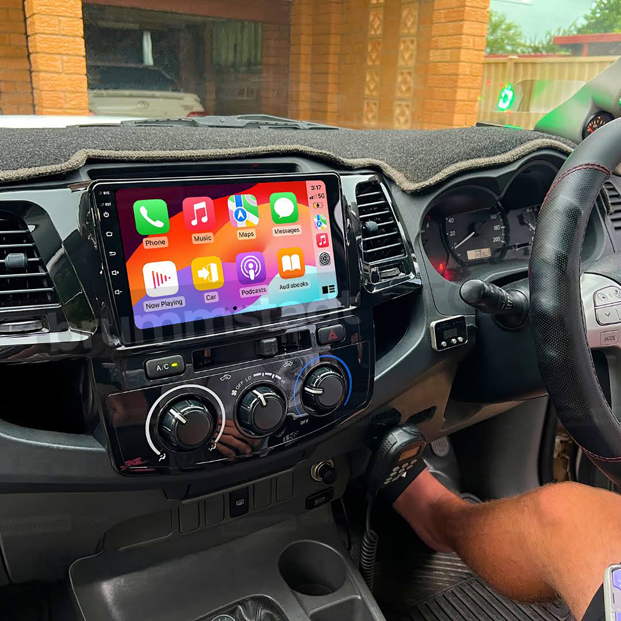 Toyota Hilux 2007-14 dash with glossy 9-inch Apple CarPlay & Android Auto head unit, vivid icons, steering-wheel control, OEM-style fascia, phone mirroring, Bluetooth, reversing-camera ready. Brummstadt.com.au
